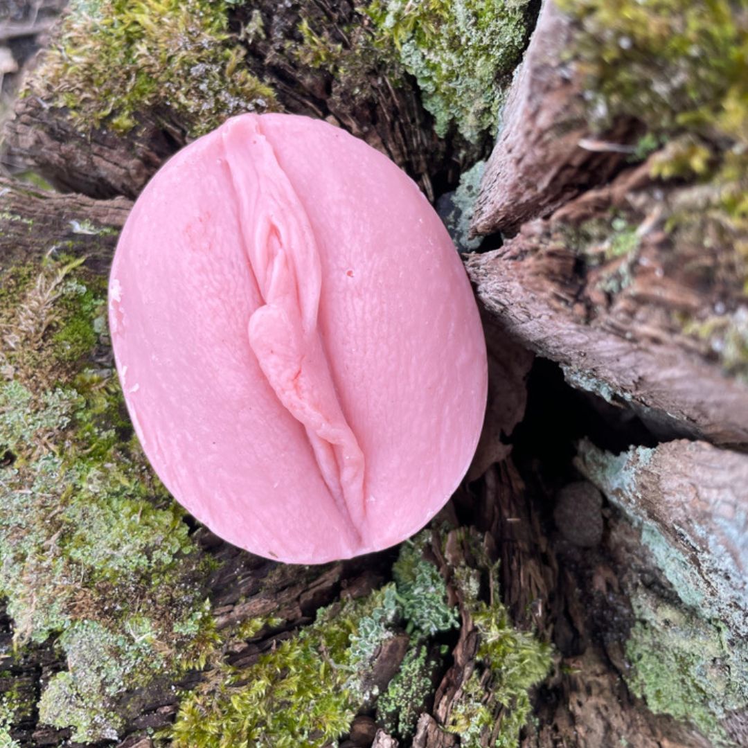 rosa Vulva Seife auf mosigem Baumstumpf, frontal fotografiert