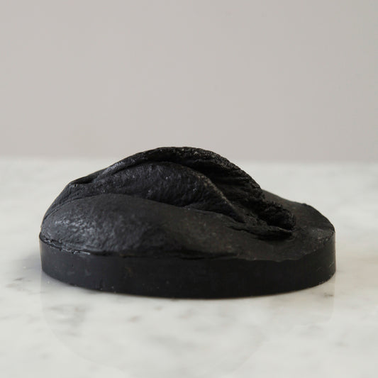 black soap with charcoal and jojoba oil for oily skin, vulva shaped. Seitenansicht der schwarzen Seife, sie ist mit Aktivkohle und Jojobaöl wunderbar geeignet für fettige Haut